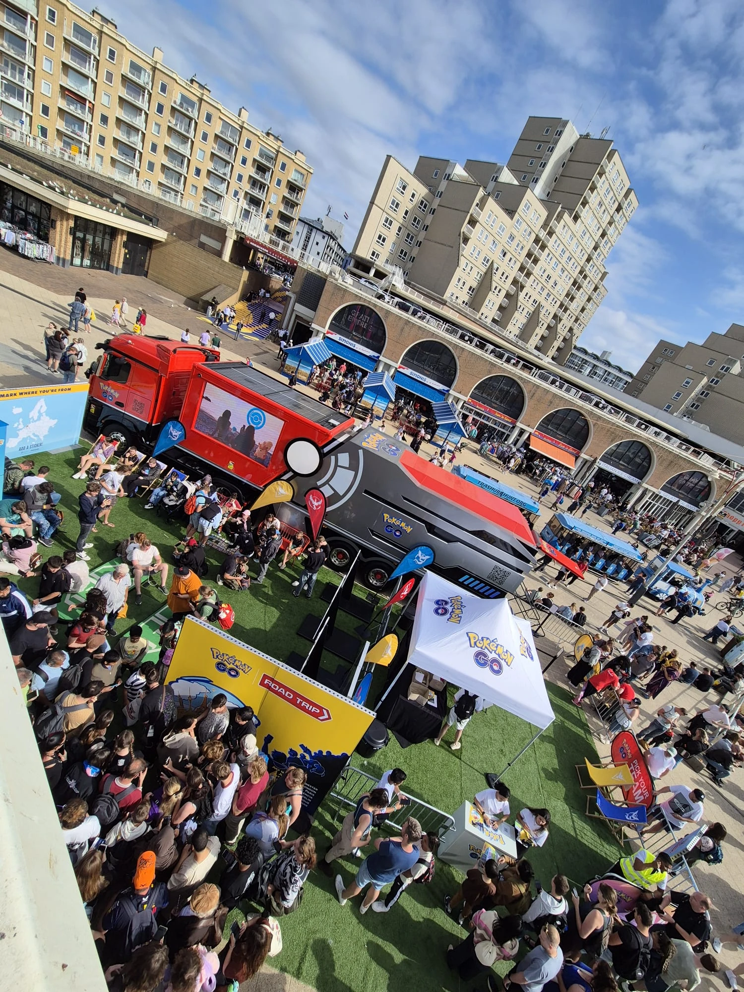 Fans gathered around a Pokémon GO truck and activity tents at an outdoor community event