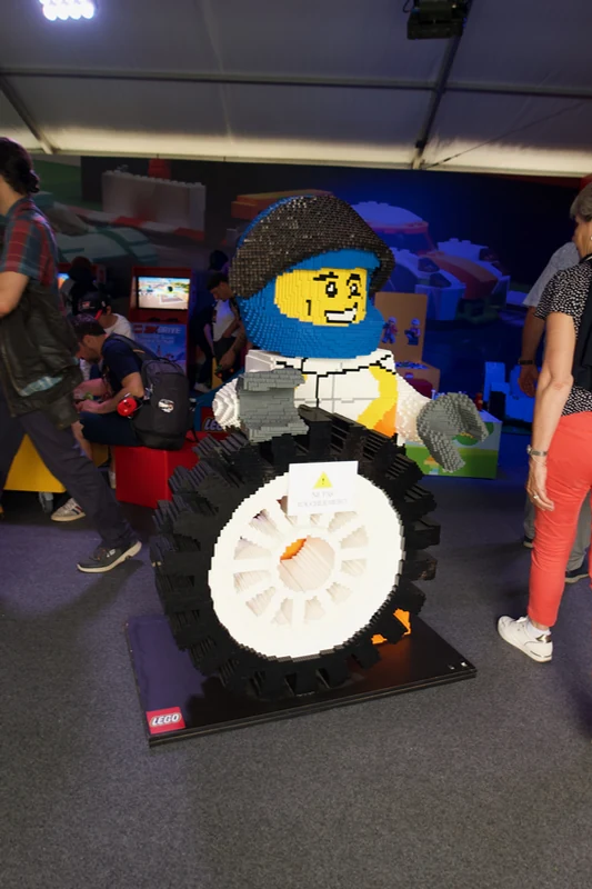 Large LEGO racing character holding a tyre